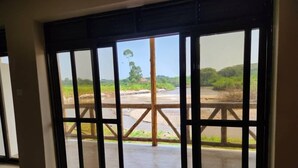 Habitación con ventanas amplias que ofrecen vistas a un río y vegetación.