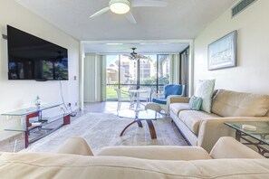 Relax in this stylish living room with a flat-screen TV, glass coffee table, and comfortable sofa.