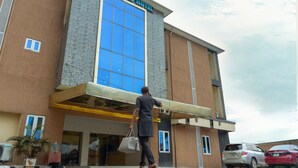 A hotel with a prominent blue glass facade and a sign reading "LIMBURG HOTEL". - Limburg Hotel (Port Harcourt)