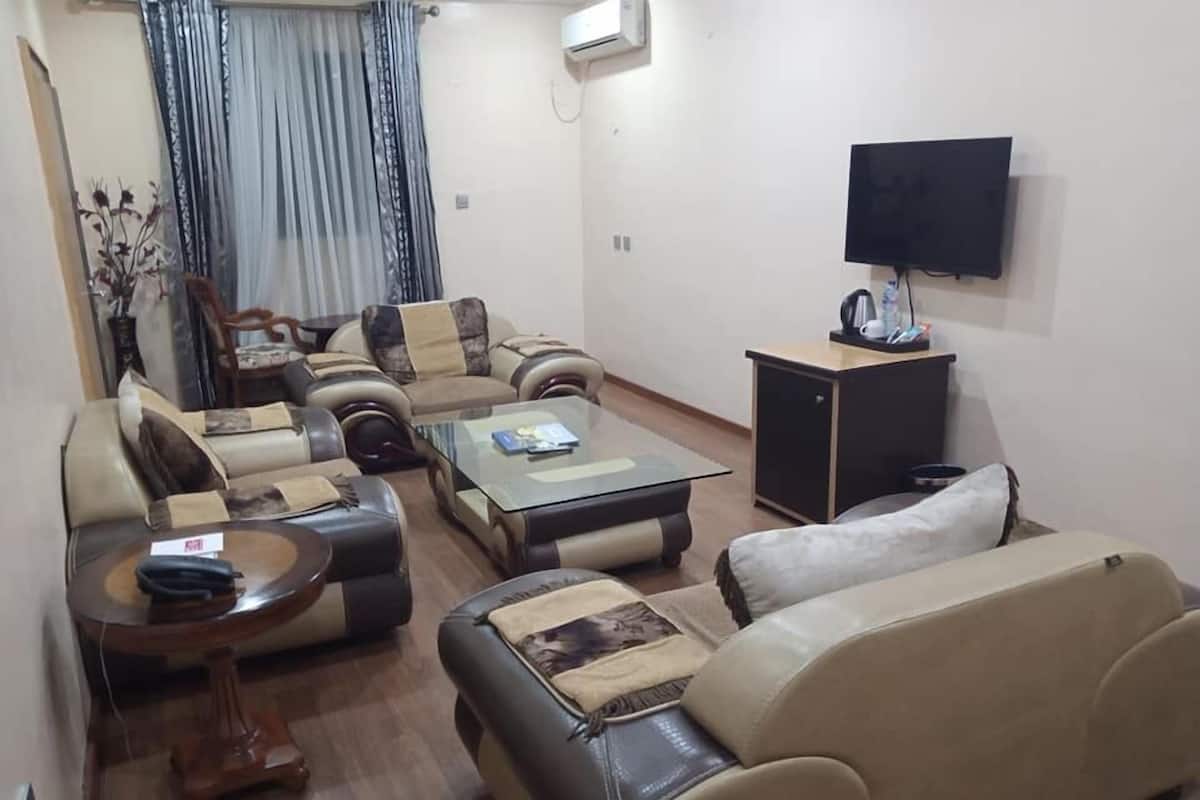 A living room with a sofa set, a coffee table, a TV, and a cabinet.