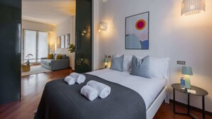 Een moderne hotelkamer met een groot bed, een bank en een eethoek.