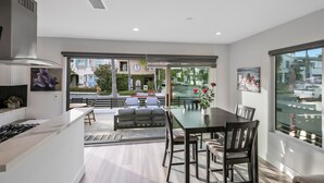 Una cocina moderna con comedor, ventanas amplias y vista a la calle.