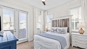 A bedroom with a bed, a dresser, a ceiling fan, and a window with blinds. - 30A:6-Seater Golf cart, Bikes, Beach Gear, 2 Pools (Inlet Beach)