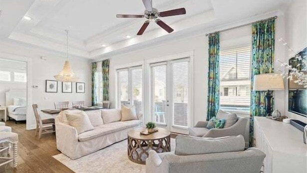 A spacious living room with a ceiling fan, a sofa, a coffee table, and a TV. - 30A:6-Seater Golf cart, Bikes, Beach Gear, 2 Pools (Inlet Beach)