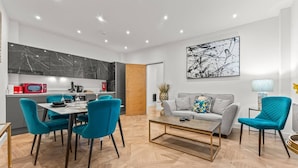 A modern living room with a grey sofa, teal chairs, and a coffee table. - Large Apartment by Spinningfields - Manchester - Pass the Keys (Salford)