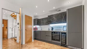 Eine moderne Küche mit grauen Schränken, einem eingebauten Backofen und einer Mikrowelle.