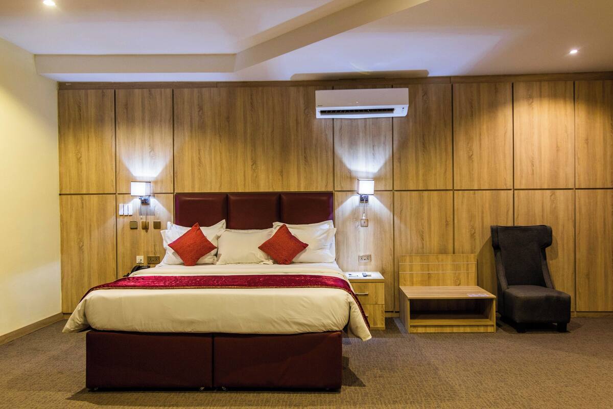 أسرّة تيمبور بديك وميني بار وخزنة داخل الغرفة ومكتب