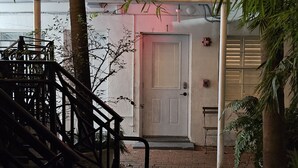 A staircase leading to a door with a fire alarm. - Sirena Azul SoBe Suite 1 (Miami Beach)