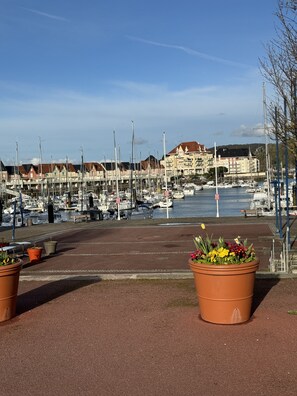 A marina with boats docked, a clear sky, and buildings in the background. - Appartement Cosy vue Port (Dives-sur-Mer)