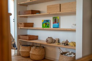 A room with wooden shelves displaying baskets, a ceramic pot, and small figurines. - Le Galion, Maison Chaleureuse et Authentique (Saint-Valery-sur-Somme)