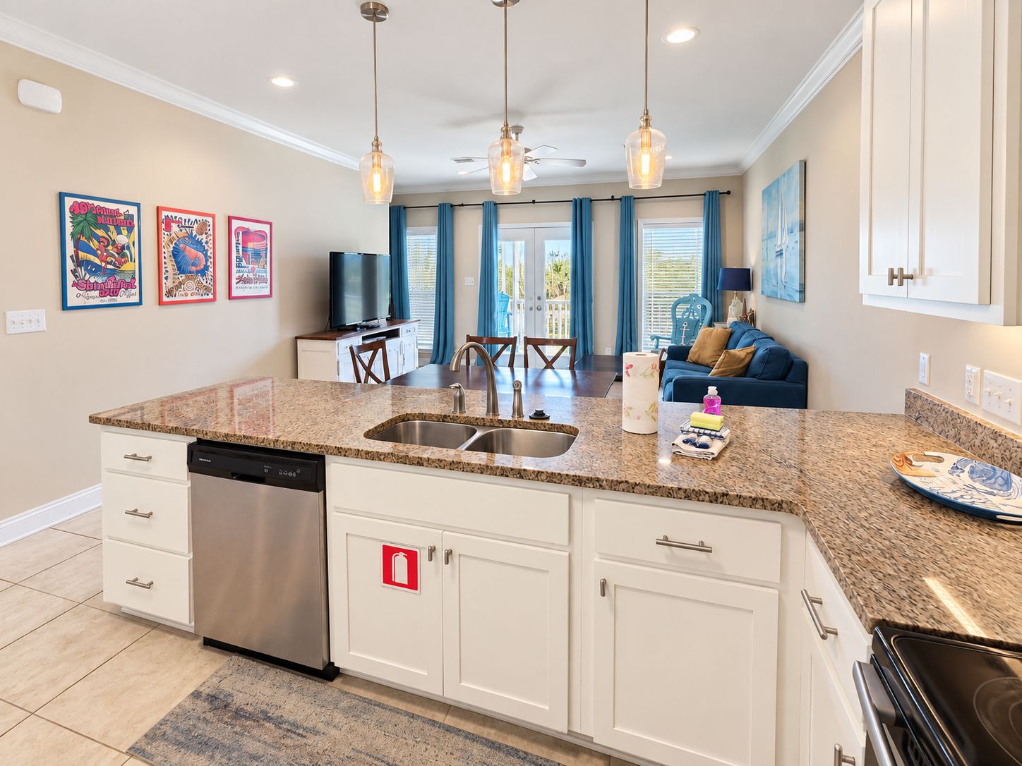 A modern kitchen with granite countertops, stainless steel appliances, and pendant lighting.