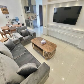 Studio – deluxe, 1 kingsize-seng, ikke-røyk, fjellutsikt | Oppholdsområde | En 55-tommers smart-TV med kabel-kanaler