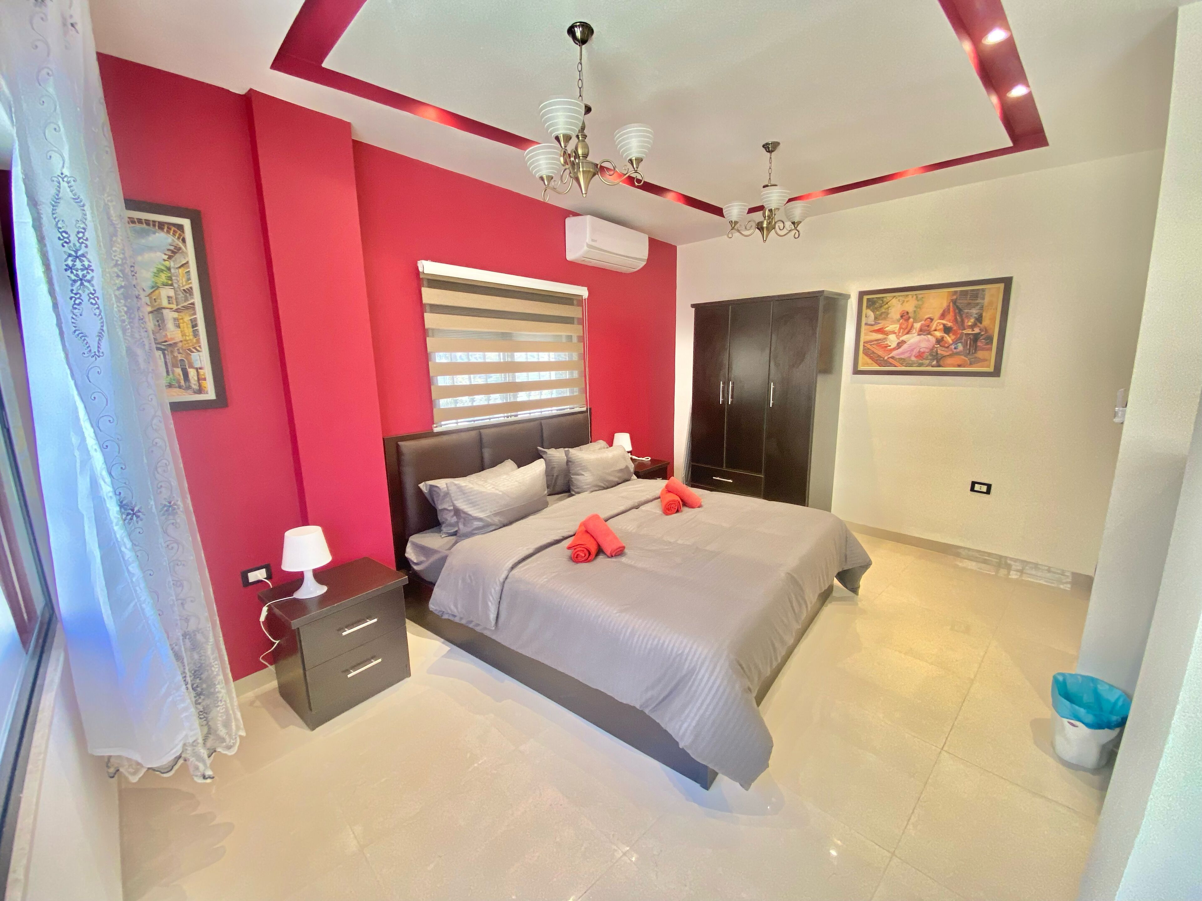 A bedroom with a bed, bedside table, lamp, wardrobe, and a ceiling fan.