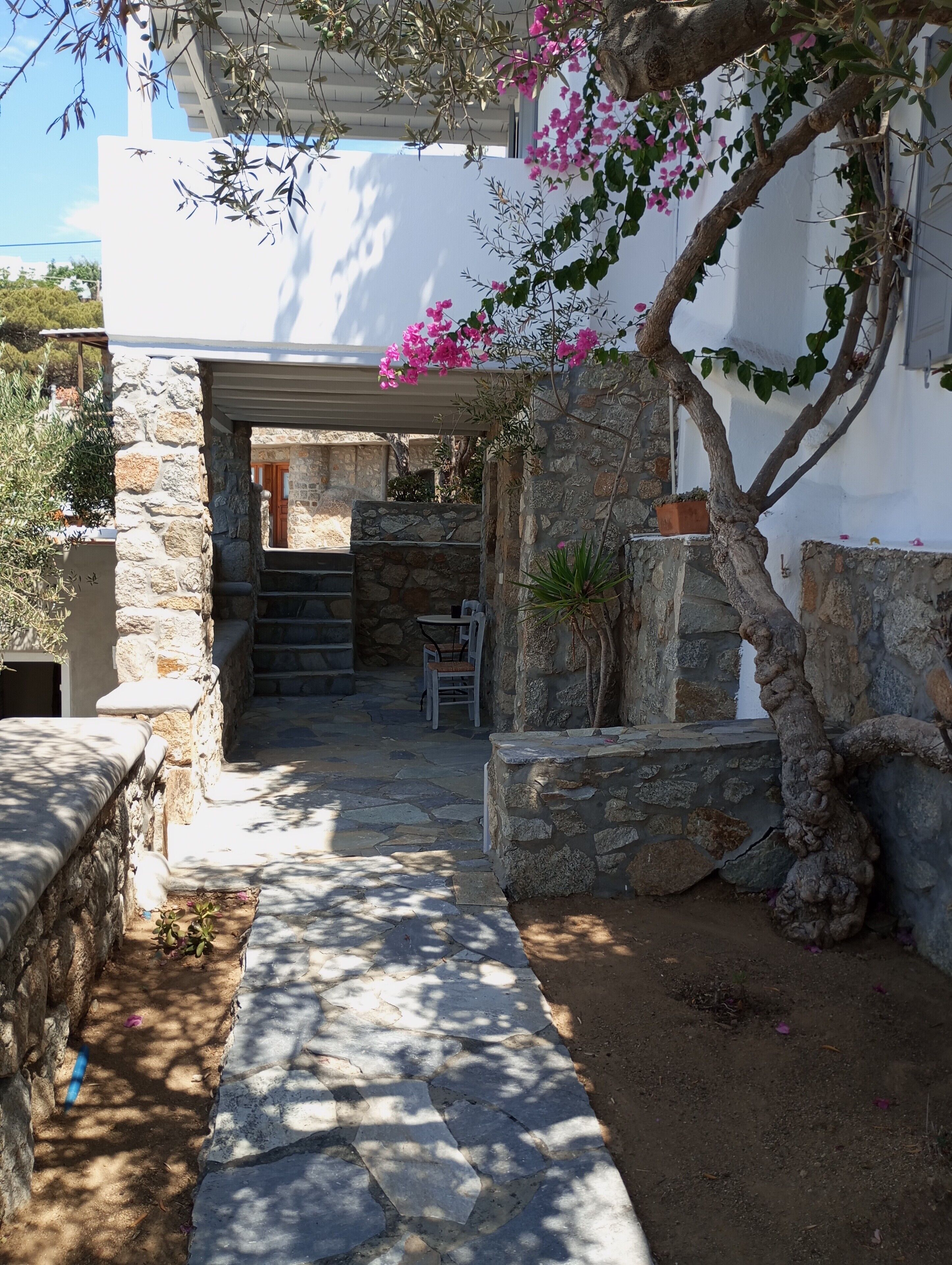 A stone pathway leading to a white building with a covered entrance.
