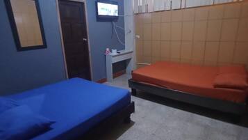 A room with two beds, a TV, and an air conditioner.
