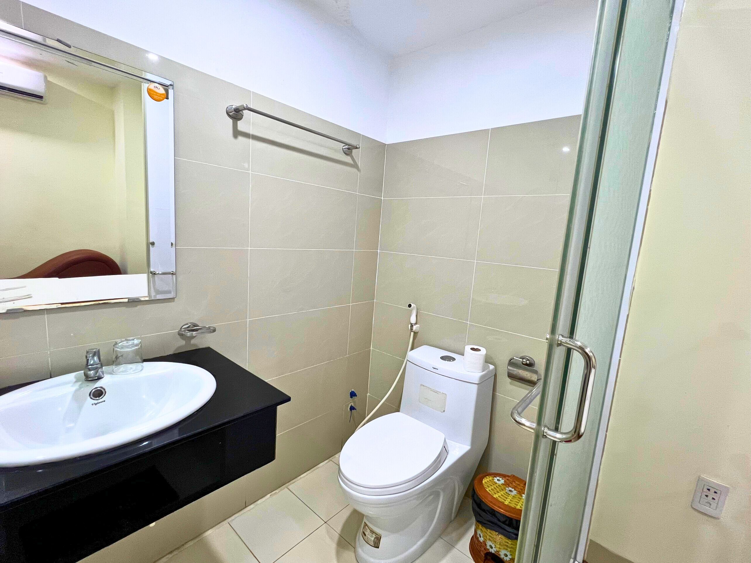A bathroom with a sink, toilet, and a glass shower enclosure.