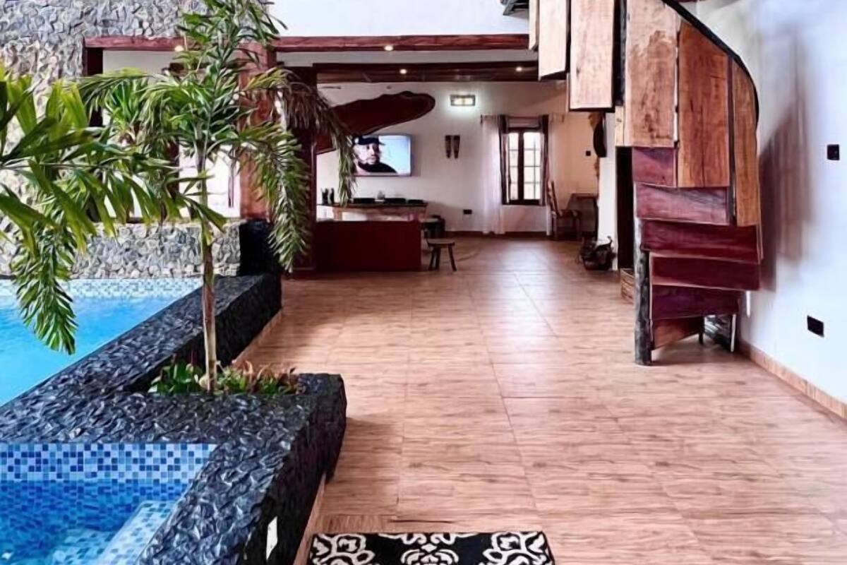 Un vaste espace intérieur doté d’une piscine, d’un plancher en bois et d’un tapis à motifs.