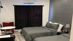Ein modernes Schlafzimmer mit zwei Betten, einem Schreibtisch, einem Stuhl und einem roten Gerät.