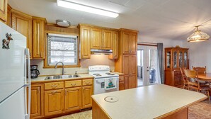Una cocina con armarios de madera, un refrigerador blanco, una estufa y una isla grande.