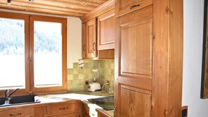 Una cocina con armarios de madera, un ventanal y una licuadora.