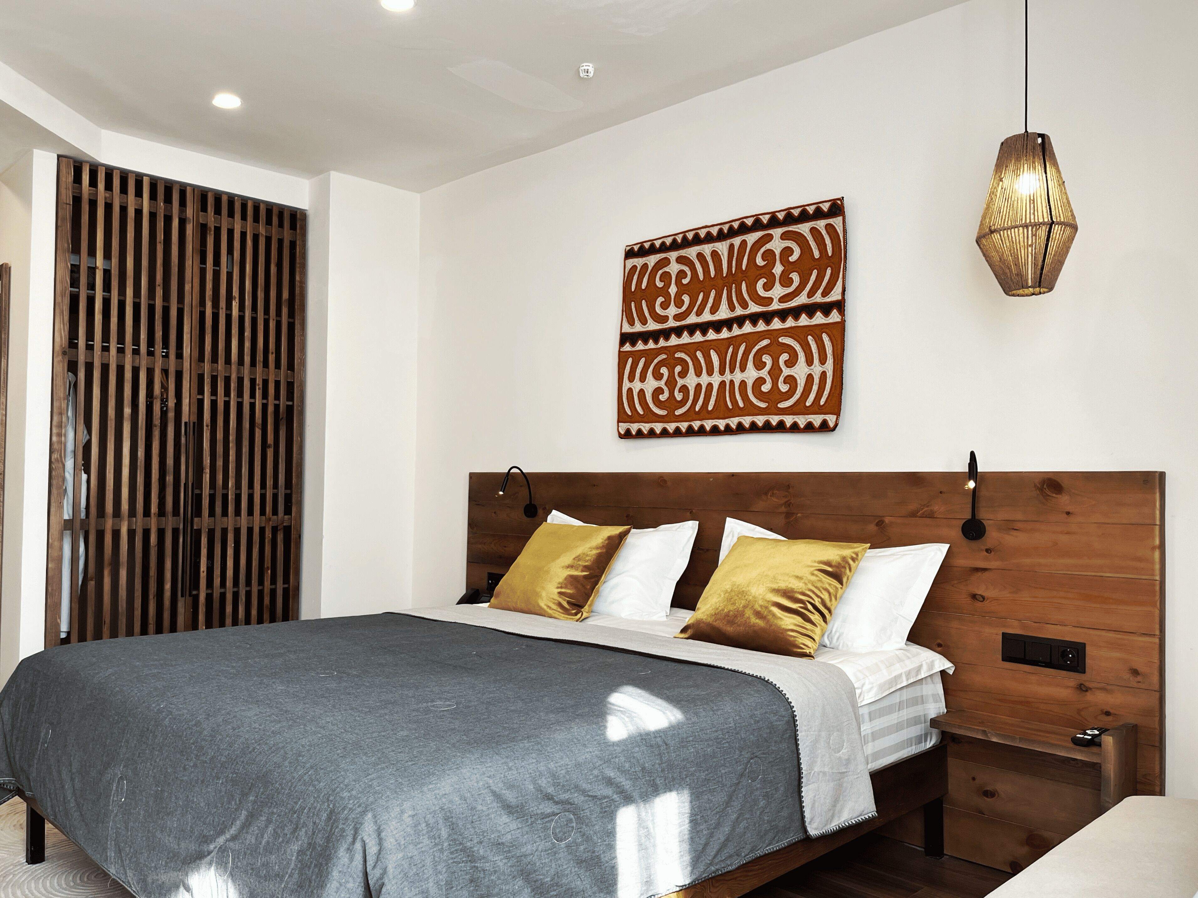 Un dormitorio moderno con una cama grande, cabecera de madera y un adorno de pared.