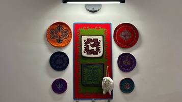 A wall with a central decorative panel featuring a sheep and geometric patterns, surrounded by circular designs with animal motifs.