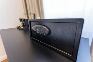 Una caja fuerte negra con teclado numérico sobre una mesa negra.