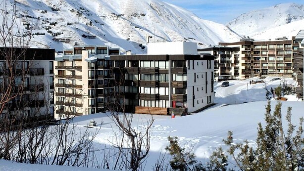 A modern multi-story hotel with balconies, set against a snowy mountainous backdrop. - 50m from ski slopes, 4th floor, balcony, tv, 34m², Tignes (Tignes)