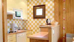 A compact kitchen with a microwave, coffee maker, and a sink. - 50m from ski slopes, 4th floor, balcony, tv, 34m², Tignes (Tignes)