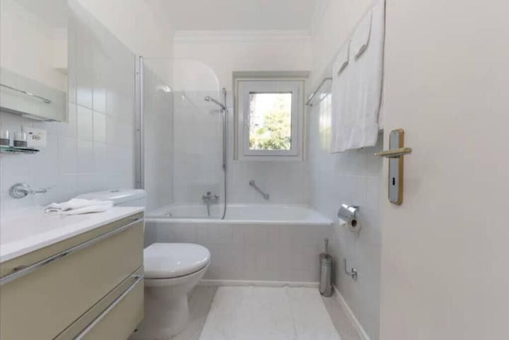 A bathroom with a toilet, a bathtub, and a shower.
