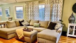 A living room with a sectional sofa, a small table, and a cabinet.