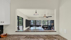 A kitchen with a granite countertop, a ceiling fan, and a view of the outdoors. - Pick of the Pines Pinehurst (Pinehurst)