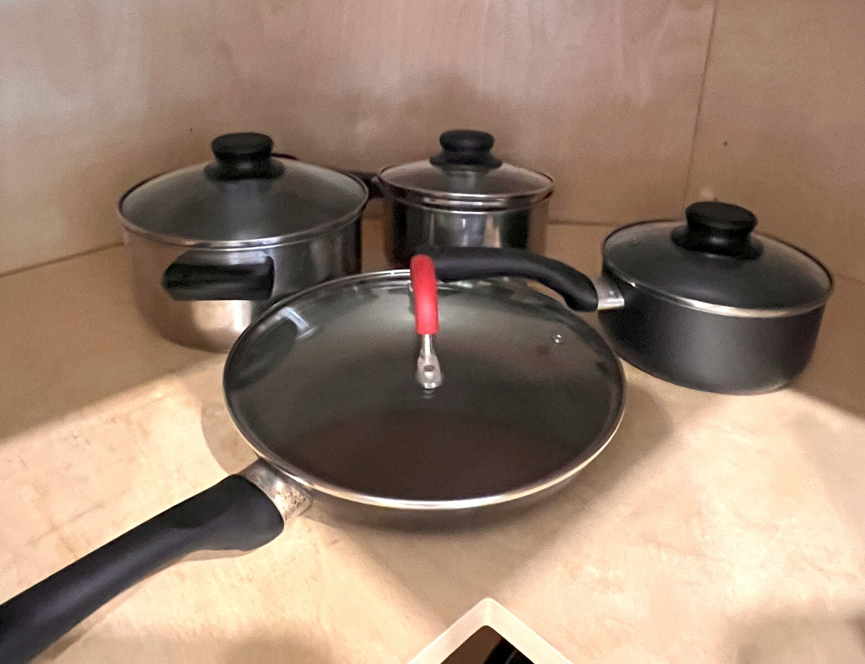 Una cocina con cuatro ollas sobre una encimera.