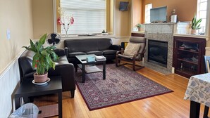 Una sala de estar con chimenea, un sofá, una mesa de centro y una planta en maceta.