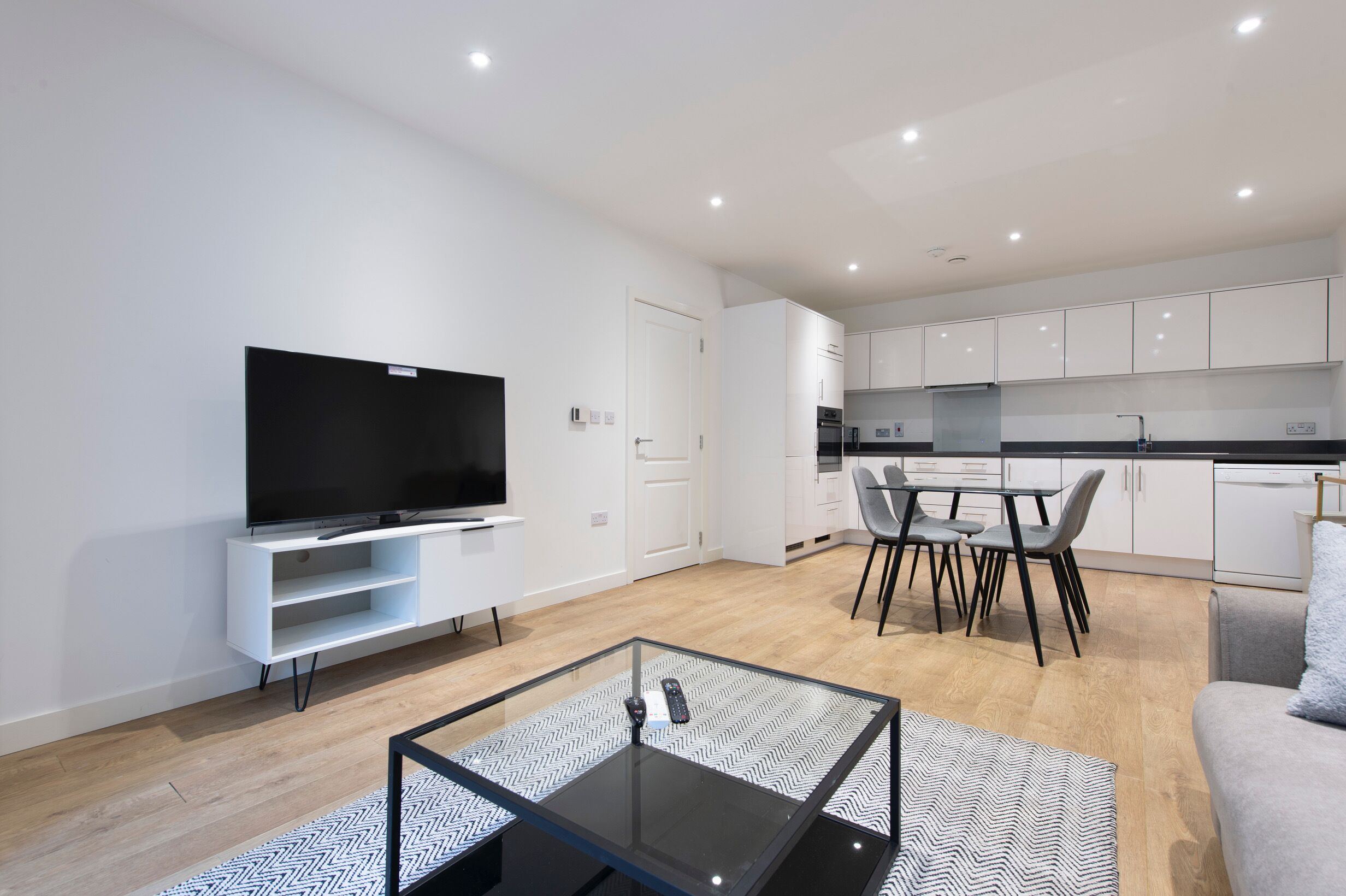A modern apartment with a living area, dining space, and kitchen.