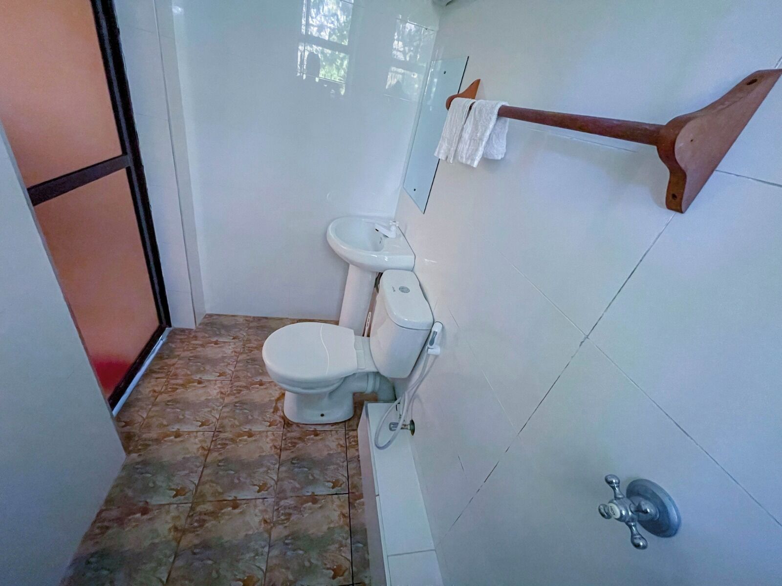 A bathroom with a toilet, a sink, and a shower area.