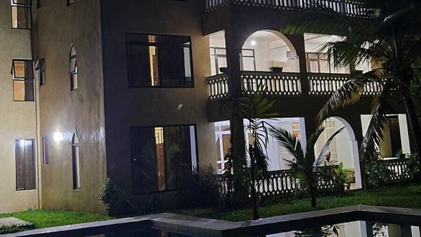A multi-story hotel with balconies and a swimming pool. - Silent Palms (Diani Beach)