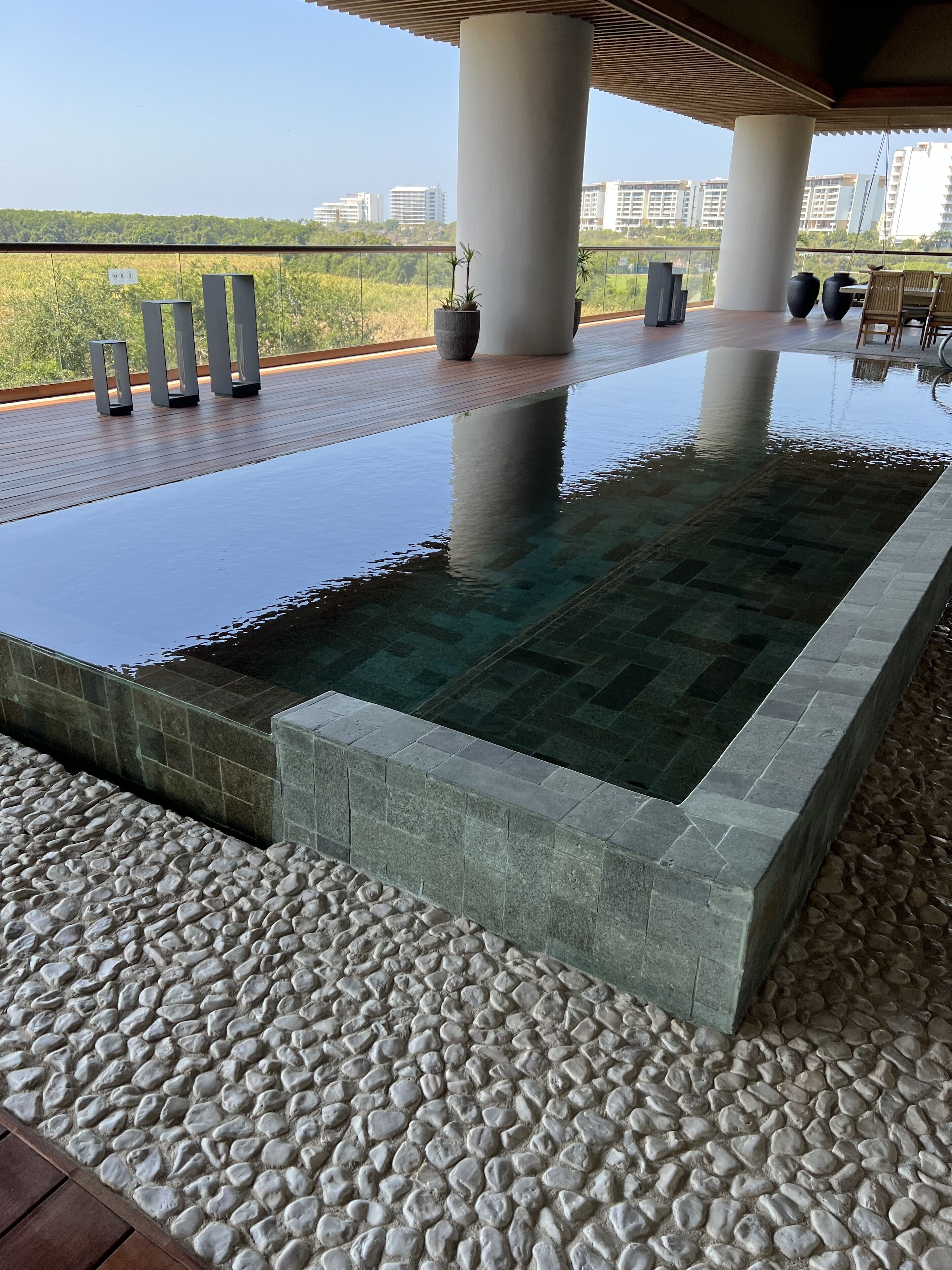 Una piscina infinita moderna con una vista despejada del paisaje urbano al fondo.