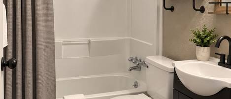 Un baño con bañera, inodoro y lavabo.