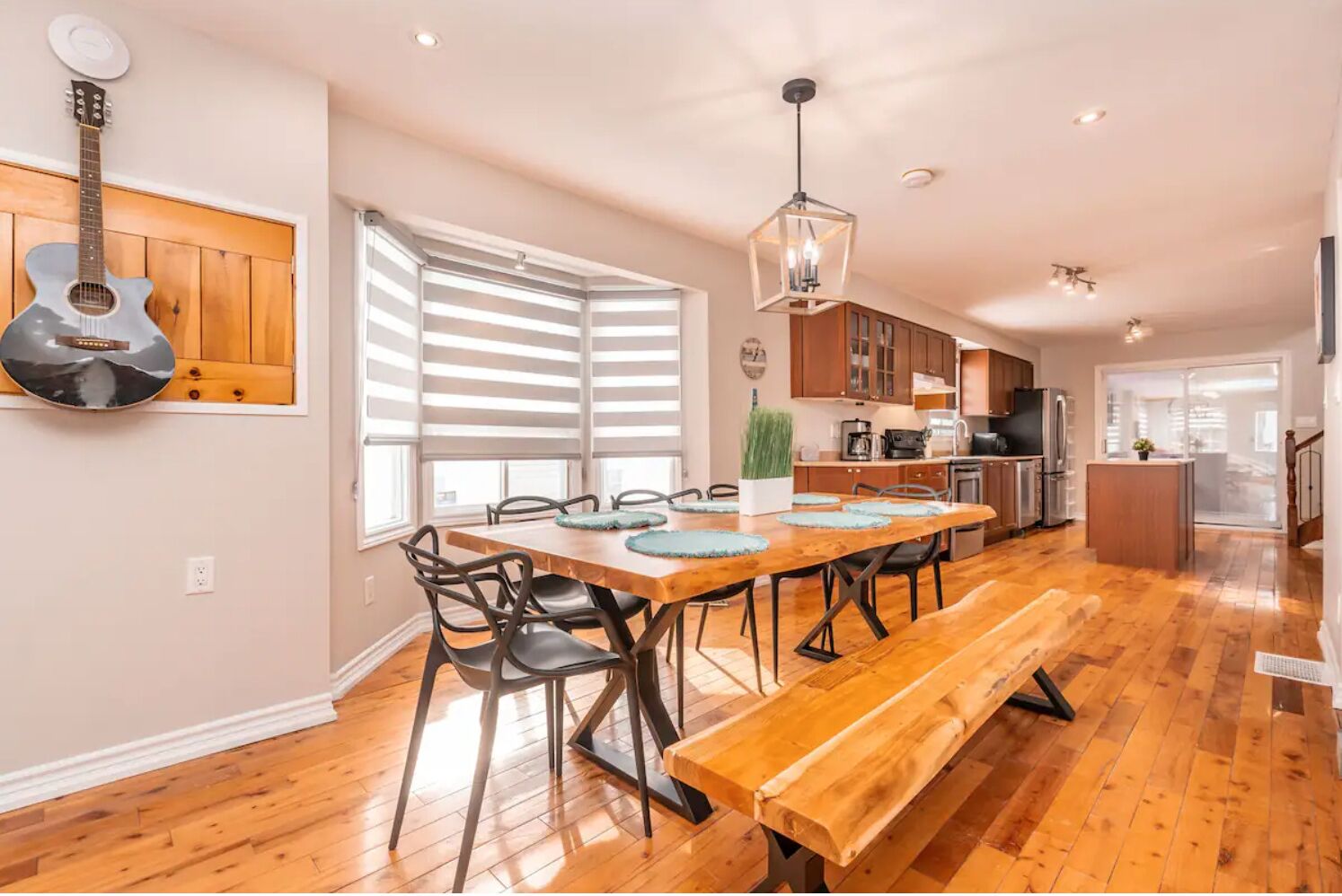 A spacious kitchen with wooden cabinets, a dining table with chairs, and a bench.