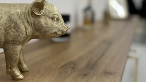 A wooden table with a gold pig figurine on it.
