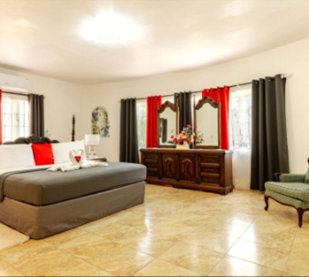 Una habitació amb un llit, una petita taula de nit, una cadira i un mirall.