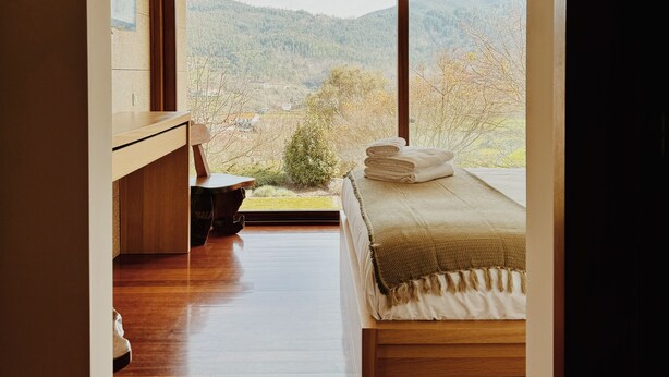 A bedroom with a large window, a bed, a desk, and a chair. - Quinta Trindade (Arouca)