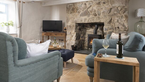 Ein gemütliches Wohnzimmer mit Kamin, Fernseher und Sitzgelegenheiten.