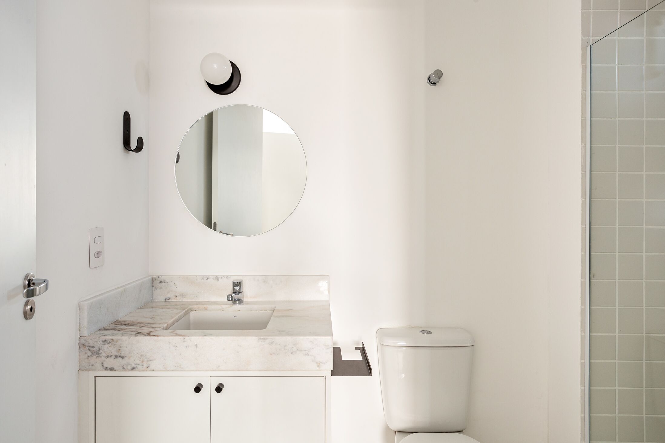 Un bagno con lavandino bianco, uno specchio e un water.