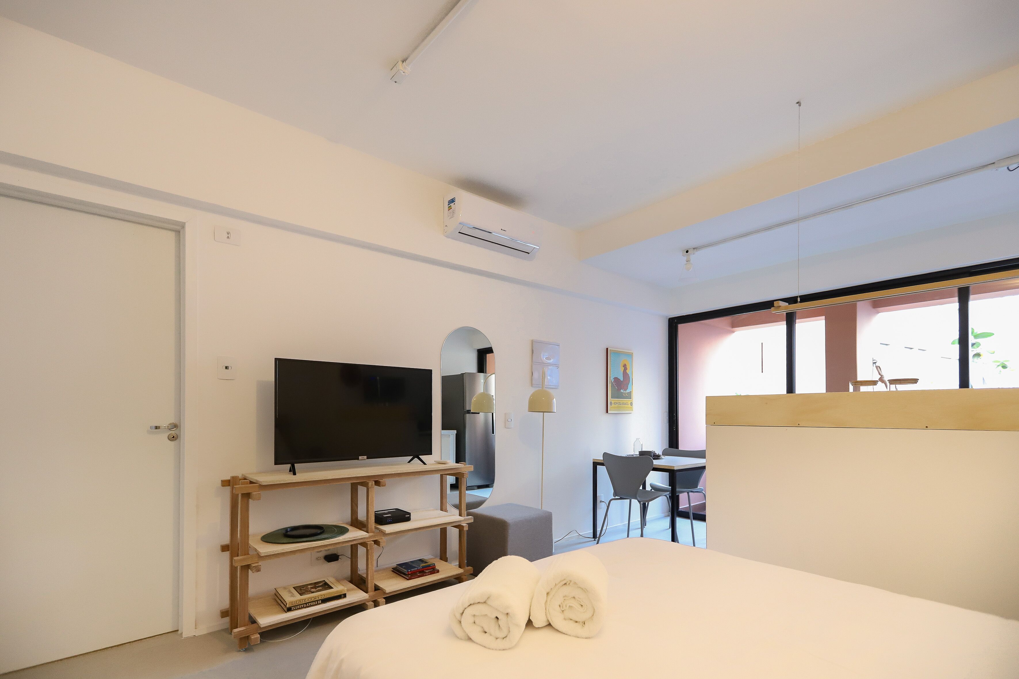 Una habitación de hotel moderna con cama, televisión, escritorio y silla.