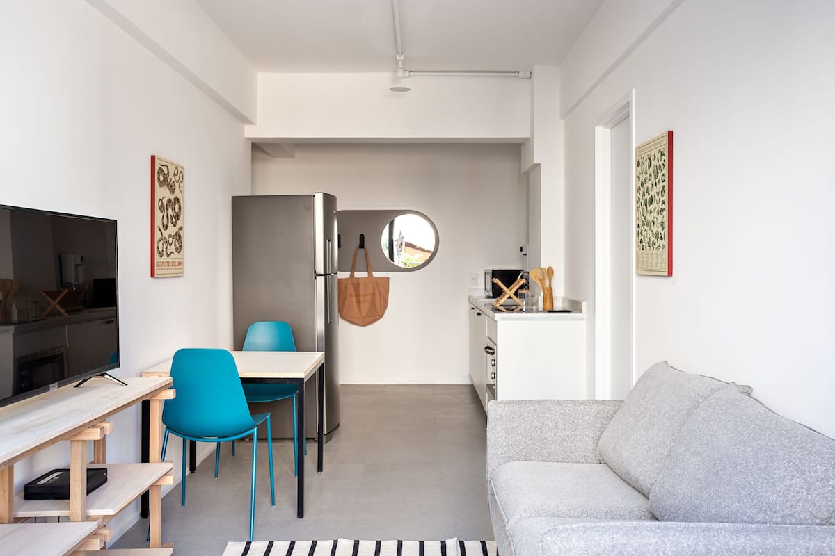 A compact living space with a kitchenette, a dining area, and a seating area.