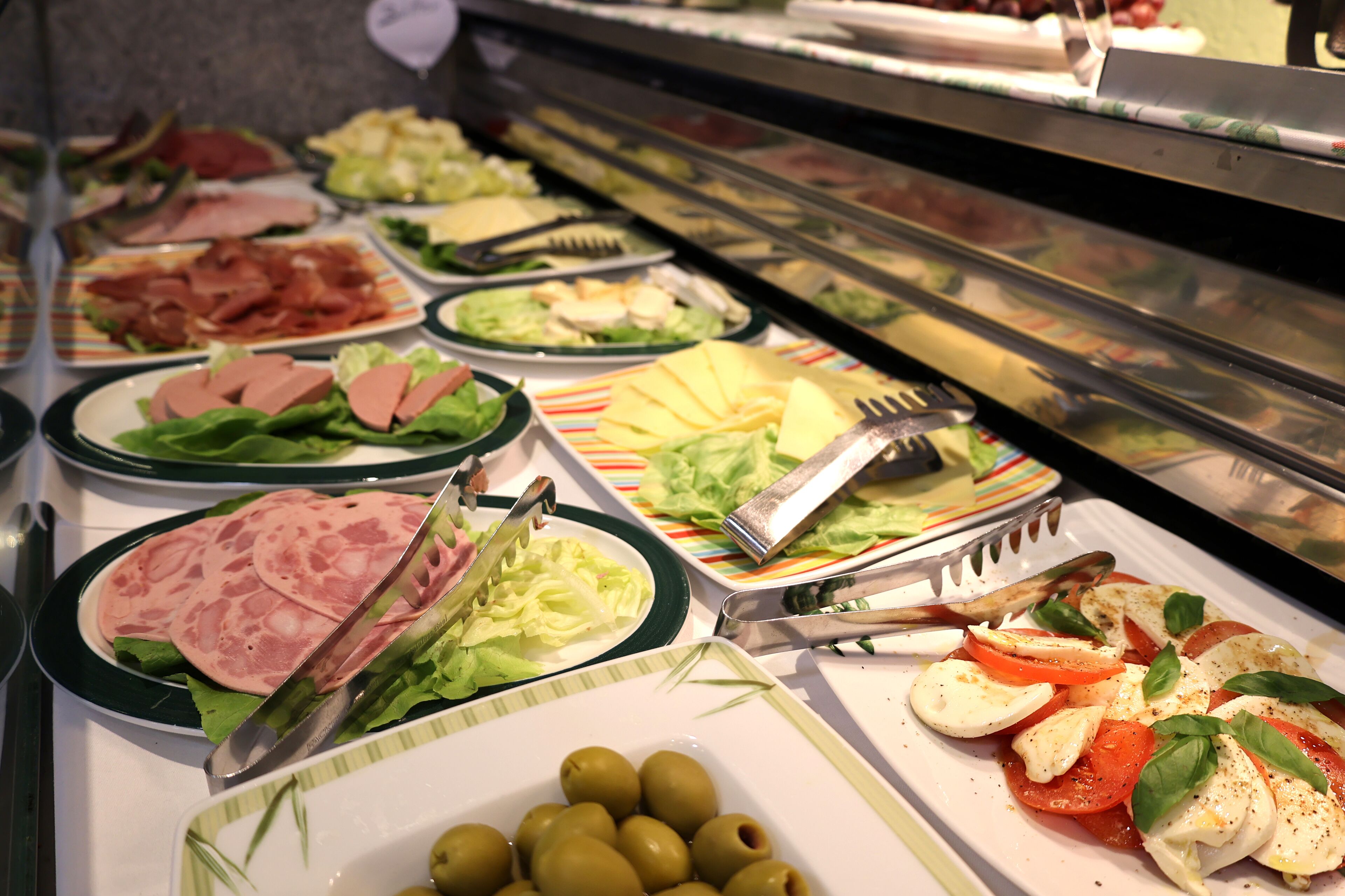 A buffet with various food options including salads, meats, and vegetables.