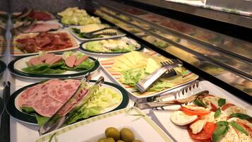 A buffet with various food options including salads, meats, and vegetables.