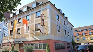 Un hotel con fachada a cuadros, varias ventanas y un cartel que indica que es un hotel.